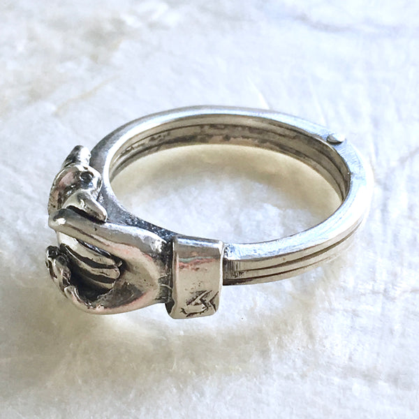 Ring with two hands and online a heart in the middle